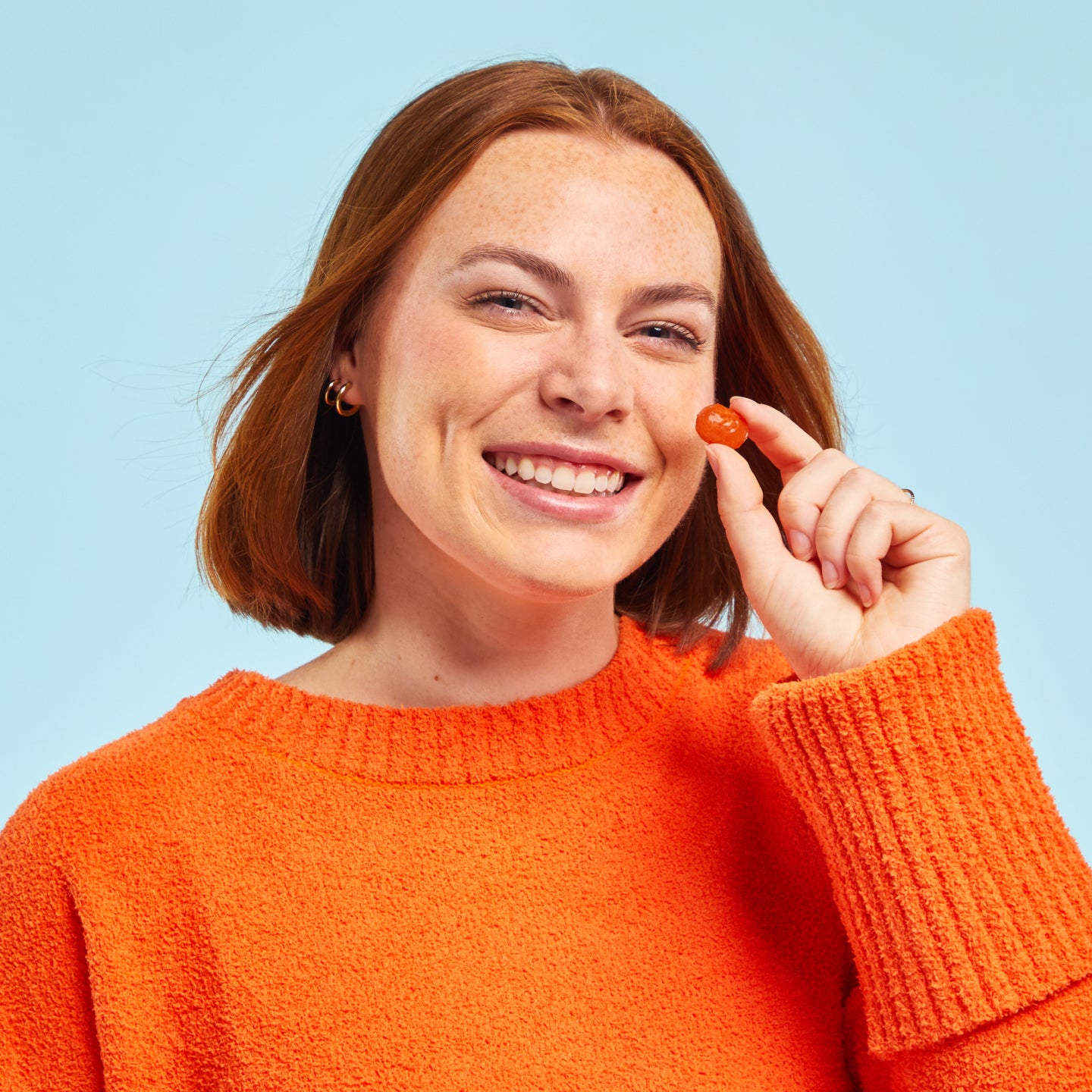 Woman holding a Sootheez Throat Soothing Drop