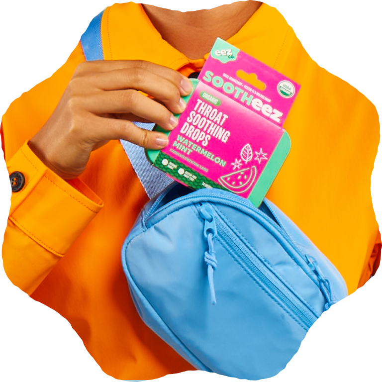 Hand taking a package of Sootheez Throat soothing drops out of a fanny pack